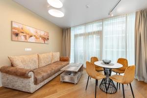 a living room with a couch and a table at Sun Sonata Apartments 3 in Druskininkai