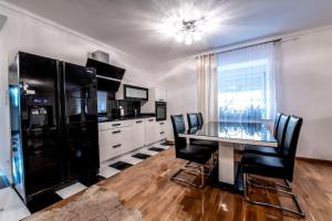a kitchen with a glass table and black chairs at Noclegi Europa in Bolesławiec