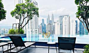 a glass table with chairs and a view of a city at The Majestic Gen Luxury Suites KLCC in Kuala Lumpur