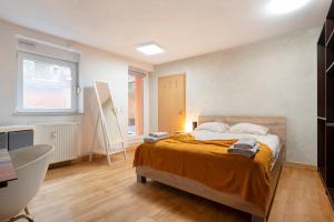 a bedroom with a bed and a desk and a window at L'écrin du fort - deux chambres parking gratuit in Luxembourg