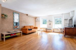 a living room with a couch and a table at L'écrin du fort - deux chambres parking gratuit in Luxembourg +16 photos