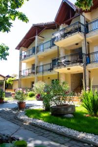 a building with balconies and plants in a yard at Pensiunea Mioara 2 Mai in 2 Mai