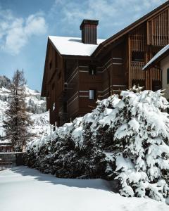 a snow covered bush in front of a building at The Chedi Andermatt in Andermatt
