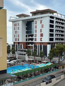 a large hotel with a swimming pool in front of it at Chloe Beach Apartment in Lezhë