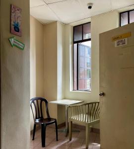 a room with two chairs and a table and a window at The Explorers Guesthouse and Hostel in Kuala Lumpur