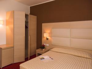 a bedroom with a bed and a large headboard at Hotel Regina in Bolzano +86 photos