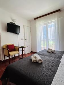 a bedroom with a bed with two towels on it at Guest House Sol in Cavtat