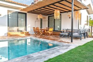 a patio with a dining table and a swimming pool at Vacation - Honeymoon House in Ortaca