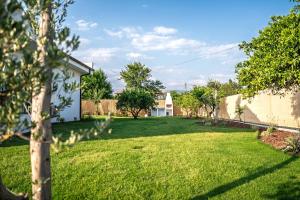 a yard with green grass and a house at Vacation - Honeymoon House in Ortaca