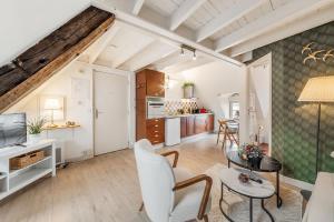 un soggiorno con sedie bianche e un tavolo di Le Ruellan charmant duplex proche plage a Saint Malo