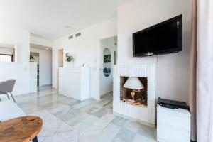 a living room with a fireplace with a tv above it at La Riviera in La Cala de Mijas