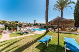a resort with a swimming pool and palm trees at La Riviera in La Cala de Mijas