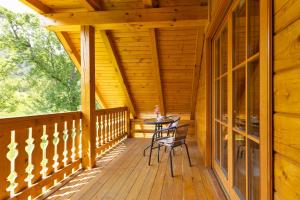a wooden porch with a table and chairs on it at Apartma Brunarca in Borovnica +8 photos