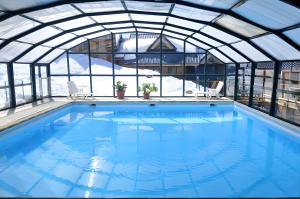サン・フランソワ・ロンシャンにあるVg83 Chalet 6 ou 8 Couchagesの屋内スイミングプール(ガラス屋根付)