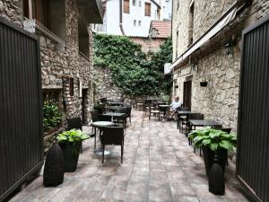 a patio with tables and chairs and a person sitting at a table at Hostal Marboré in Bielsa