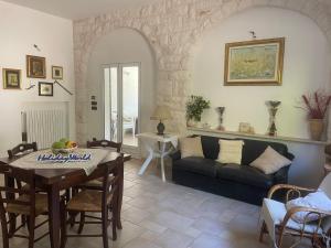 una sala de estar con un sofá y una mesa en Casina GiuSaFra by Holiday World, en Selva di Fasano