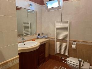 Un baño con lavabo, inodoro y espejo. en Casina GiuSaFra by Holiday World, en Selva di Fasano