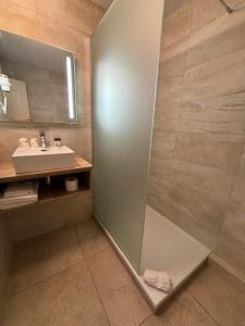 a bathroom with a shower and a sink at Hôtel Tamaris in Le Lavandou