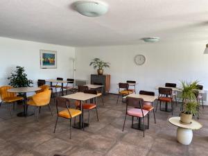 a room with tables and chairs in a room at Hôtel Tamaris in Le Lavandou