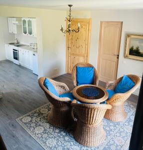 a living room with wicker chairs and a table at Už Karvelius - Sodyba Biržų mieste in Biržai +24 photos