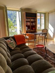 ein Wohnzimmer mit Sofa und Tisch in der Unterkunft Le Relais de Paulette et Gaston in Poligny
