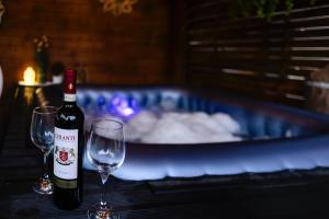 锡吉什瓦拉Casa MOMO的桌子上放有一瓶葡萄酒和两杯酒