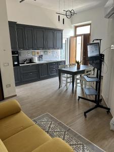 ein Wohnzimmer mit Tisch und Küche in der Unterkunft Domu e Cannonau in Nuoro