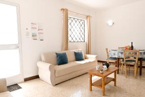 a living room with a couch and a table at Sea Blue Horizon Qawra Bay in St Paul's Bay