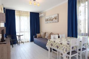 un soggiorno con tavolo e divano e una sala da pranzo di Mars Apartments in Tryavna Beach Complex a Sveti Vlas