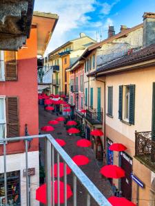 a group of red umbrellas on a street with buildings at Porta 1 in Luino