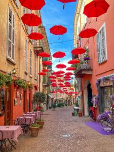 a group of red umbrellas hanging over a street at Porta 1 in Luino
