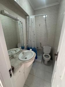 a bathroom with a sink and a toilet and a shower at Cozy T3 Monte Abraão in Queluz +2 photos