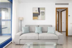 een woonkamer met een bank en een raam bij Patacona Splendor in Valencia +51 foto's