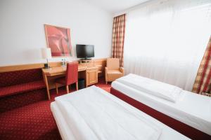 Postel nebo postele na pokoji v ubytování Feringapark Hotel Unterföhring