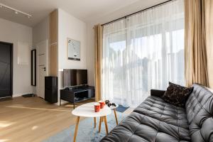a living room with a couch and a large window at Willa 27 Lakeside Retreat Łączyno by BookingHost in Łączyno