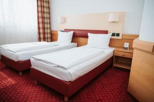 Postel nebo postele na pokoji v ubytování Feringapark Hotel Unterföhring