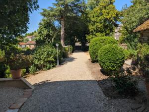 un sentiero del giardino con cespugli e un albero di Domaine du Parc Waechter a Molières