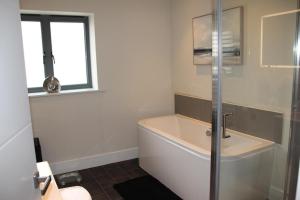 a bathroom with a bath tub and a window at Large 4 Bedroom Seaside House by the beach and cliffs in Hunstanton