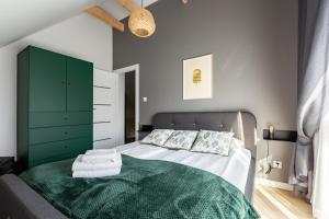 a bedroom with a bed with a green cabinet at Willa 27 Lakeside Retreat Łączyno by BookingHost in Łączyno