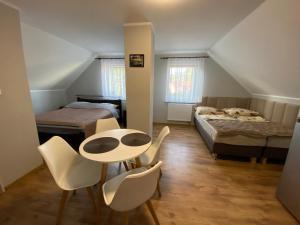a room with a table and chairs and a bed at Pokoje u Doroty in Niechorze