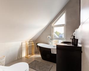 a bathroom with a bath tub and a window at Willa 27 Lakeside Retreat Łączyno by BookingHost in Łączyno +38 photos
