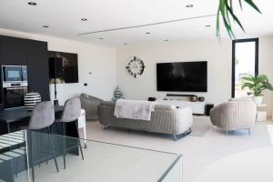 a living room with a couch and chairs and a tv at Villa El Padrino in Callao Salvaje