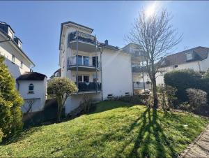 un gran edificio blanco con un árbol en el patio en Spacious Ferienwohnung nähe KOB Uni, 