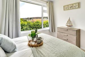 a bedroom with a bed with a large window at Cornish house 5 min drive to beach in Falmouth