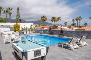 a pool table on a patio next to a swimming pool at Villa El Padrino in Callao Salvaje