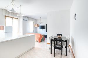 a kitchen and living room with a table and chairs at Appartamento Smeraldo Mare in Marina di Massa