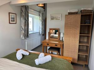 ein Schlafzimmer mit einem Bett, einem Schreibtisch und einem Spiegel in der Unterkunft Charming cosy cottage near the Lake District in Penrith
