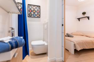 a bathroom with a bed and a toilet in a room at Colmar City Center - Modern Studio COCOON - BookingAlsace in Colmar