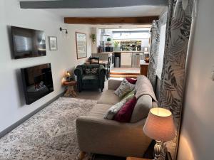 ein Wohnzimmer mit Couch und Kamin in der Unterkunft Charming cosy cottage near the Lake District in Penrith