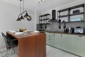 a kitchen with a wooden island in a room at Urokliwy Apartament z Ogródkiem 150 m od Plaży Parking Międzywodzie by Noclegi Renters in Międzywodzie